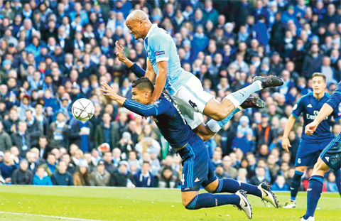 CHESTER: Manchester City’s Vincent Kompany jumps over Real Madrid’s Carlos Henrique Casemiro during the Champions League semifinal soccer match between Manchester City and Real Madrid, at the City of Manchester stadium in Manchester, England, yesterday. — AP