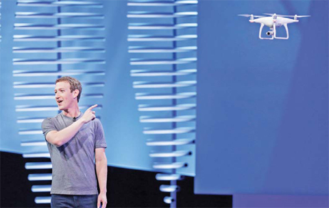 SAN FRANCISCO: Facebook CEO Mark Zuckerberg points to a drone flying behind him during his keynote address at the F8 Facebook Developer Conference on Tuesday. — AP