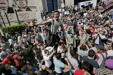 Egyptians shout slogans against Egyptian President Abdel-Fattah el-Sissi during a protest against the decision to hand over control of two strategic Red Sea islands to Saudi Arabia in front of the Press Syndicate, in Cairo, Egypt, Friday, April 15, 2016. Graffiti on the wall at background showing Tamer Abdel Raouf and Ahmed Mahmoud, two journalists were killed during 2011 uprising. (AP Photo/Amr Nabil)