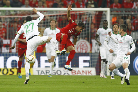 Bremen's Florian Grillitsch, left, and Bayern's Juan Bernat challenge for the ball during the German soccer cup (DFB Pokal) semi finalnmatch between FC Bayern Munich and SV Werder Bremen at the Allianz Arena stadium in Munich, Germany