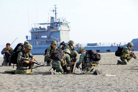 SAN JOSE: Philippine Marines take positions during a beach landing as part of the 11-day “Balikatan” (shoulder-to-shoulder) annual joint US and Philippine military exercises at San Jose airport in Antique province in the central Philippines yesterday. US and Philippine troops began major exercises on April 4 as China’s state media warned “outsiders” against interfering in tense South China Sea territorial disputes. — AFP