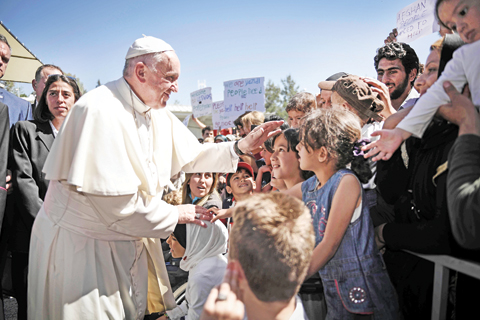 LESBOS: Pope Francis greets children during his visit to the Moria detention center for migrants and refugees near Mytilene on the Greek island of Lesbos yesterday.  - AFPn