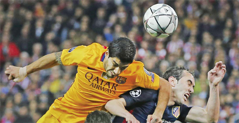 MADRID: Barcelona’s Luis Suarez (left) elbows Atletico’s Diego Godin as they jump for a high ball during the Champions League 2nd leg quarterfinal soccer match between Atletico Madrid and Barcelona at the Vicente Calderon stadium on Wednesday April 13, 2016. — AP