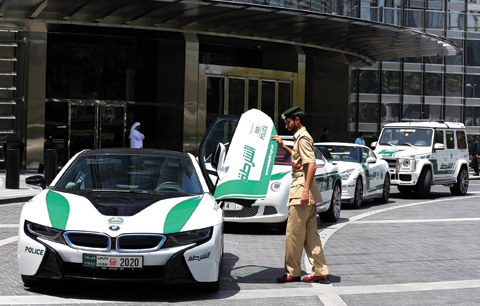 Dubai police Lt Saif Sultan Rashed Al-Shamsi, who oversees the tourist police’s patrol section, pushes down one of the twin scissor doors of the $140,000 BMW i8 during a demonstration in Dubai.