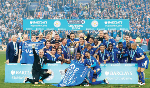 LEICESTER: Leicester players pose with the Premier League trophy after winning the league and the English Premier League football match between Leicester City and Everton at the King Power Stadium central England yesterday. — AFP