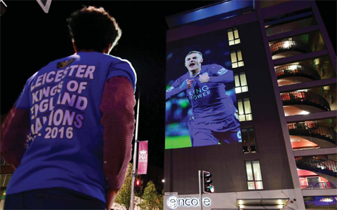 LEICESTER: A Leicester City football fan looks up at a large projection of an image of Leicester City’s striker Jamie Vardy on the side of a building as the city celebrate’s their team becoming the English Premier League champions in central Leicester, eastern England, on Monday. —AFP