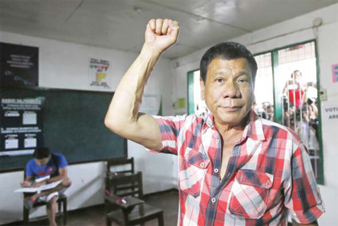 DAVAO CITY: Presidential candidate Mayor Rodrigo Duterte clenches his fist prior to voting in a polling precinct at Daniel R Aguinaldo National High School in the Matina district of his hometown yesterday. —AP
