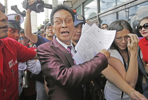 MANILA: Salvador Panelo, lawyer of presidential candidate Rodrigo Duterte, gestures as he holds documents before meeting Philippine senator and vice-presidential candidate Antonio Trillanes IV at a bank in Pasig, east of Manila, yesterday. — AP