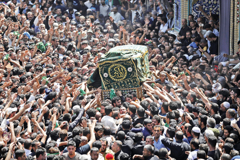 BAGHDAD: Shiite pilgrims carry a symbolic coffin at the holy Muslim Shiite shrine of Imam Moussa Al-Kadhim as pilgrims gather to commemorate his death at the northern neighborhood of Kadhimiyah in Baghdad, Iraq yesterday. — AP