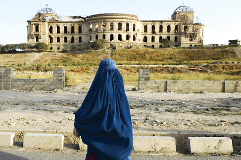 KABUL: This file photo taken on August 22, 2014 shows an Afghan burqa-clad woman in front of the ruined Darul Aman Palace, once the residencenof former Afghan king Amanullah Khan between 1920-1929. — AFP