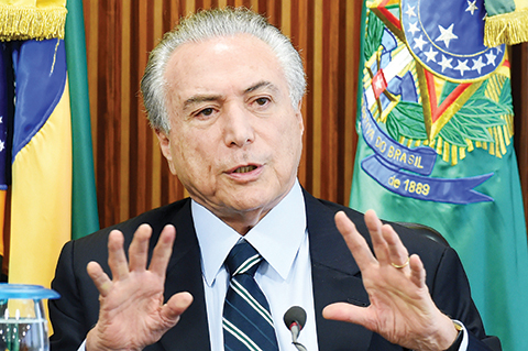 Brazilian acting President Michel Temer gestures during the first ministers meeting at the Planalto Palace in Brasilia, on May 13, 2016.nTemer kicks off his new administration Friday, seeking to resuscitate the economy and steer clear of the corruption scandal that helped bring down his predecessor. / AFP PHOTO / EVARISTO SA