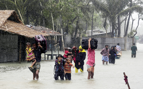 COX BAZAR: Bangladeshi villagers make their way to shelter in Cox’s Bazar yesterday as Cyclone Roanu approached. — AFP
