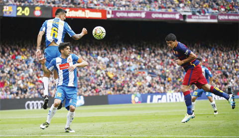 BARCELONA: FC Barcelona’s Luis Suarez (R) heads the ball to score against Espanyol’s Enzo Roco, (L) and Javi Lopez during a Spanish La Liga soccer match between FC Barcelona and Espanyol at the Camp Nou stadium. — AP