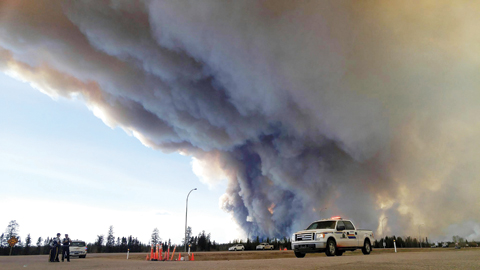 FORT MCMURRAY: In this image released by the Alberta Royal Canadian Mounted Police (RCMP), members of the RCMP monitor the Fort McMurray wildfire on Saturday. — AFP