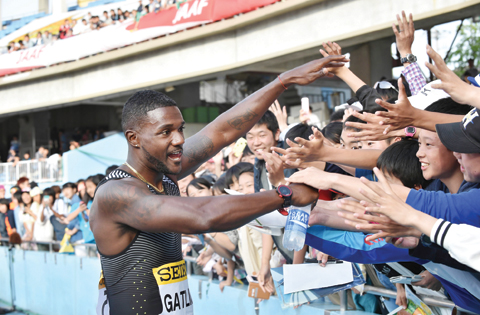 KAWASAKI: Justin Gatlin of the US (L) meets supporters after winning the men’s 100 meters athletics event during the Seiko Golden Grand Prix at Todoroki Stadium.— AFP