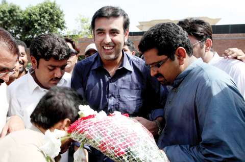 MULTAN: Abdul Qadir Gilani (C), elder brother of freed Ali Haider Gilani, son of former Pakistani premier Yousuf Raza Gilani, receives flowers from supporters outside his residence. — AFP