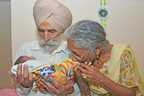 AMRITSAR, PUNJAB, India : Indian father Mohinder Singh Gill, 79, and his wife Daljinder Kaur, 70, pose for a photograph as they hold their newborn baby boy Arman at their home in Amritsar yesterday. — AFP