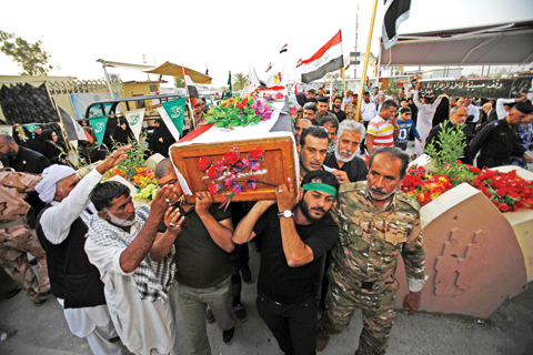 NAJAF: Iraqi mourners attend the funeral of a soldier who was killed during a military operation to recapture the town of Bashir yesterday in the holy city of Najaf. — AFP