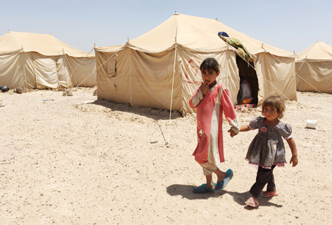 AMRIYAT AL-FALLUJAH, Iraq: Displaced Iraqi children stand outside a tent at a newly-opened camp in this government-held town on Sunday. — AFP