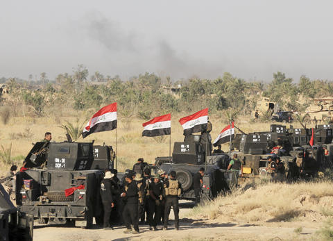 Smoke billows on the horizon as Iraqi military forces prepare for an offensive into Fallujah to retake the city from Islamic State militants yesterday. - AP 