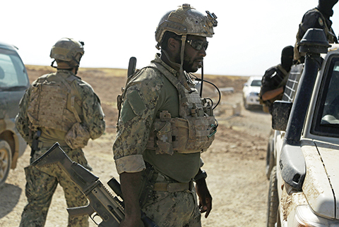 Armed men in uniform identified by Syrian Democratic forces as US special operations forces are seen in the village of Fatisah in the northern Syrian province of Raqa on May 25, 2016.  US-backed Syrian fighters and Iraqi forces pressed twin assaults against the Islamic State group, in two of the most important ground offensives yet against the jihadists. The Syrian Democratic Forces (SDF), formed in October 2015, announced on May 24 its push for IS territory north of Raqa city, which is around 90 kilometres (55 miles) south of the Syrian-Turkish border and home to an estimated 300,000 people. The SDF is dominated by the Kurdish People's Protection Units (YPG) -- largely considered the most effective independent anti-IS force on the ground in Syria -- but it also includes Arab Muslim and Christian fighters.  / AFP PHOTO / DELIL SOULEIMAN