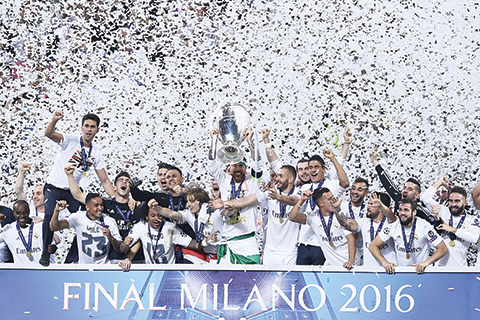 Real Madrid's players hold the trophy after winning the UEFA Champions League final football match between Real Madrid and Atletico Madrid at San Siro Stadium in Milan, on May 28, 2016. / AFP PHOTO / FILIPPO MONTEFORTE