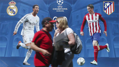 MILAN: People walk by a billboard portraying Real Madrid’s Cristiano Ronald (left) and Athletico Madrid’s Fernando Torres, at the Champions Festival event area, in Milan, Italy yesterday. The Champions League soccer final between Real Madrid and Atletico Madrid will be held at the San Siro stadium tomorrow. — AP