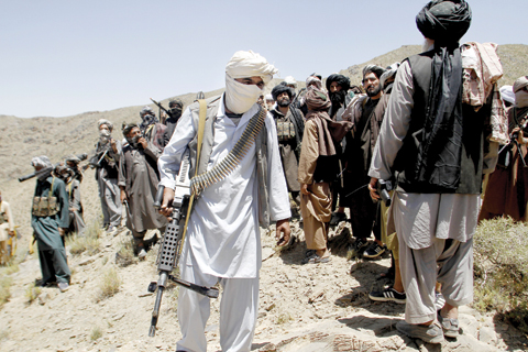 HERAT: Members of a breakaway faction of the Taleban fighters walks during a gathering, in Shindand district of Herat province, Afghanistan. Mullah Abdul Manan Niazi said yesterday he was willing to hold peace talks with the Afghan government but would demand the imposition of Islamic law and the departure of all foreign forces. — AP