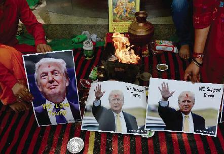 NEW DELHI: An Indian Hindu priest performs a Hawan (The Sarced Fire) ritual alongside posters bearing the image of US Republican presidential candidate Donald Trump. — AFP