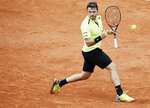 PARIS: Switzerland's Stan Wawrinka clenches his fist after winning a point as he plays Serbia's Viktor Troicki during their fourth round match of the French Open tennis tournament at the Roland Garros stadium. - AP