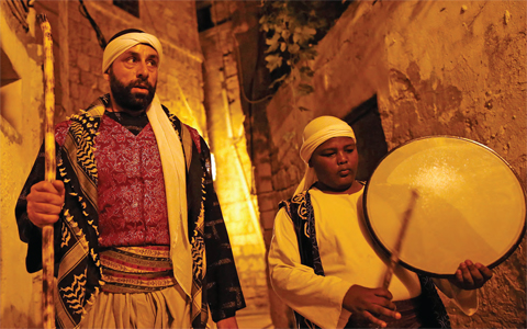 Michel Ayoub (left), an Arab-Israeli Christian man carrying out the role of a “Musaharati”, the traditional figure who awakens Muslims for the “Suhur”, the pre-dawn traditional meal before Muslims start their fast during the sacred fasting month of Ramadan, walks in the street rousing Muslim residents in the northern Israeli port city of Acre. Ayoub’s role as the city’s “Musaharati” is a traditional one during the sacred fasting month, but Ayoub is by no means a traditional holder of the position: He is Christian. The tradition had disappeared from Acre until Ayoub, who usually works in construction, revived it 13 years ago. He says it was his way to preserve his grandfather’s heritage and by carrying on the Musaharati tradition, he says he was “only doing my duty by helping our Muslim brothers who endure hunger and thirst” during the fasting month. — AFP
