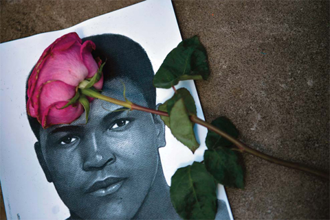 A flower and an image of Muhammad Ali are seen as people leave items to pay their respects to boxing legend Muhammad Ali at the Muhammad Ali Center in Louisville, Kentucky. — AFP