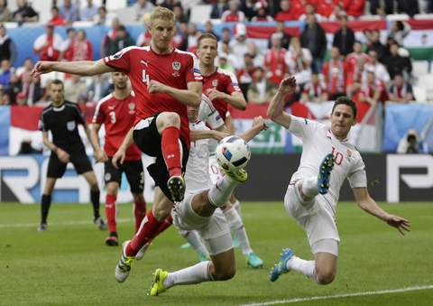 BORDEAUX: Austria's Martin Hinteregger, left, and  Hungary's Zoltan Gera, right, go for the ball during the Euro 2016 Group F soccer matchnbetween Austria and Hungary at the Nouveau Stade in Bordeaux, France, yesterday. - AP