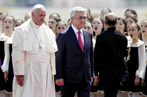 Pope Francis, left, and Armenian President Serzh Sargsyan walk past a children's choir during welcoming ceremony at Zvaretnots airport at Yereven, Armenia, Friday, June 24, 2016. Pope Francis is in Armenia for a three-day visit. (AP Photo/Alexander Zemlianichenko)