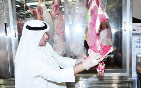 A Kuwait Municipality inspector checks the quality of meat during a campaign in Farwaniya.