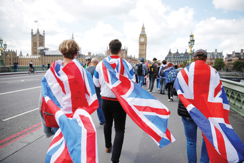 LONDON:  People walk over Westminster Bridge wrapped in Union flags, towards the Queen Elizabeth Tower (Big Ben) and The Houses of Parliament. - AFP 