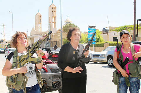 QAA, Lebanon: Lebanese Christian women hold weapons as residents of this Christian village near Lebanon’s border with war-ravaged Syria secure the area yesterday after two waves of suicide bombings struck the village, killing and wounding several people. —AFP