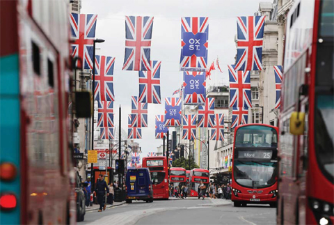 LONDON: Union flags are attached between buildings along Oxford Street in central London yesterday. — AFP