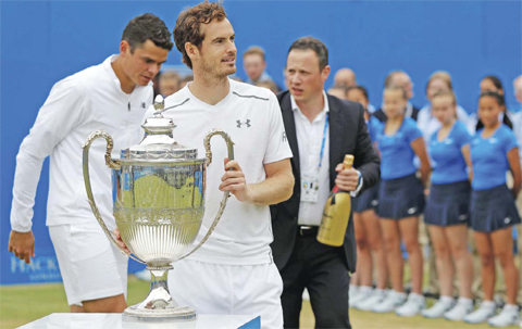 LONDON: Britain’s Andy Murray (2L) is presented with the trophy after winning the men’s singles final match against Canada’s Milos Raonic (L) at the ATP Aegon Championships tennis tournament at the Queen’s Club in west London on Sunday. Murray won the match 6-7, 6-4, 6-3. — AFP