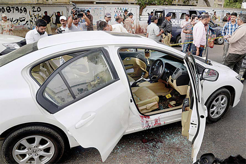 KARACHI: Pakistani investigators and journalists gather around the blood-stained car of famous Sufi singer Amjad Sabri after an attack in Karachi, Pakistan, yesterday. —AP