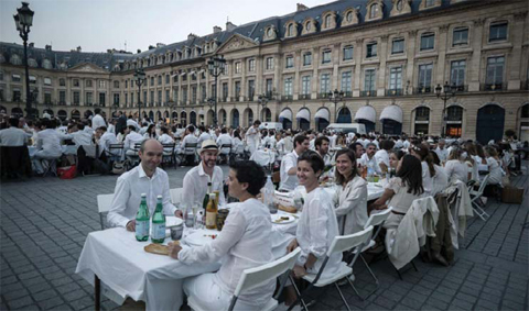 People dressed in white gather for the ìDiner en Blancî (Dinner in White) event at the place Vendome in Paris on June 8, 2016. — AFP photos