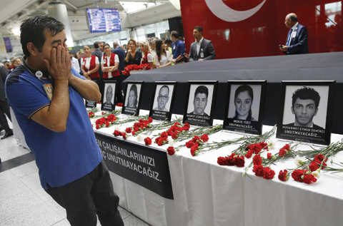 ISTANBUL: Family members, colleagues and friends of the victims of Tuesday blasts gather for a memorial ceremony at the Ataturk Airport yesterday. — A