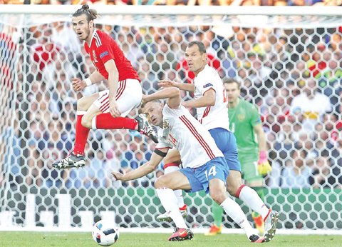TOULOUSE: Wales’ Gareth Bale, left, and Russia’s Vasili Berezutski challenge for the ball during the Euro 2016 Group B soccer match between Russia and Wales at the Stadium municipal in Toulouse, France, Monday. — AP