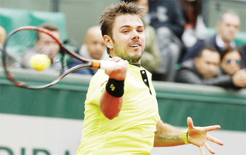 PARIS: Switzerland’s Stan Wawrinka slams a forehand to Spain’s Albert Ramos-Vinolas during their quarterfinal match of the French Open tennis tournament at the Roland Garros stadium, yesterday. Wawrinka won 6-2, 6- 1, 7-6. (Inset) Great Britain’s Andy Murray reacts after winning a point during his men’s quarter-final match against France’s Richard Gasquet. — AP