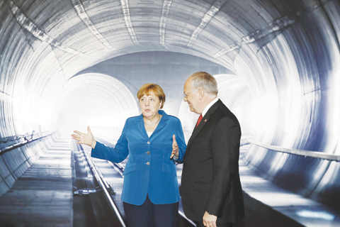 ERSTFELD, Switzerland: Swiss Federal President Johann Schneider-Ammann listens to German Chancellor Angela Merkel on the opening day of the Gotthard rail tunnel yesterday. — AP