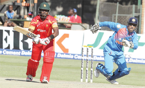 HARARE: Zimbabwe’s Elton Chigumbura, left, plays a shot as Indian wicketkeeper MS Dhoni fields, during the T20 International cricket match between Zimbabwe and India at Harare Sports Club, yesterday. — AP