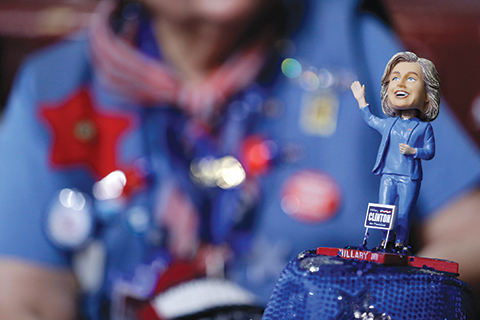 A delegate wears a hat with a bubble-head doll of Democratic Presidential candidate Sec. Hillary Clinton during the first day of the Democratic National Convention in Philadelphia , Monday, July 25, 2016. (AP Photo/John Locher)