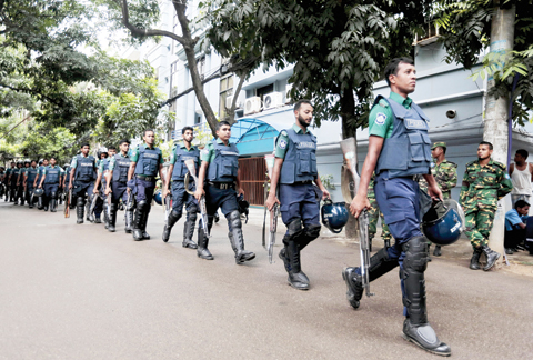 DHAKA: Bangladeshi policemen patrol the area around the site of an attack in Dhaka, yesterday. Bangladeshi forces stormed the Holey Artisan Bakery in Dhaka’s Gulshan area where heavily armed militants held dozens of people hostage yesterday morning, rescuing some captives including foreigners. — AP
