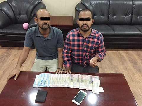 KUWAIT: This handout photo released by the Interior Ministry yesterday shows a man accused of bribing an officer to release a detainee, along with the cash he offered