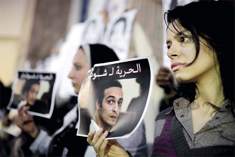 CAIRO: In this Dec 9, 2015 file photo, Egyptian journalists hold posters calling for the release from prison detention of Mahmoud Abou-Zeid, known as Shawkan, in front of the Syndicate of Journalists building. —AP
